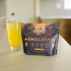 ERO ELEVATE Peach Mango Caffeine Drink Mix - Dietary Supplement for Energy, Focus, Hydration, and Endurance. Natural flavors with 150mg caffeine per serving, shown in vibrant orange drink next to resealable pouch on a kitchen counter.